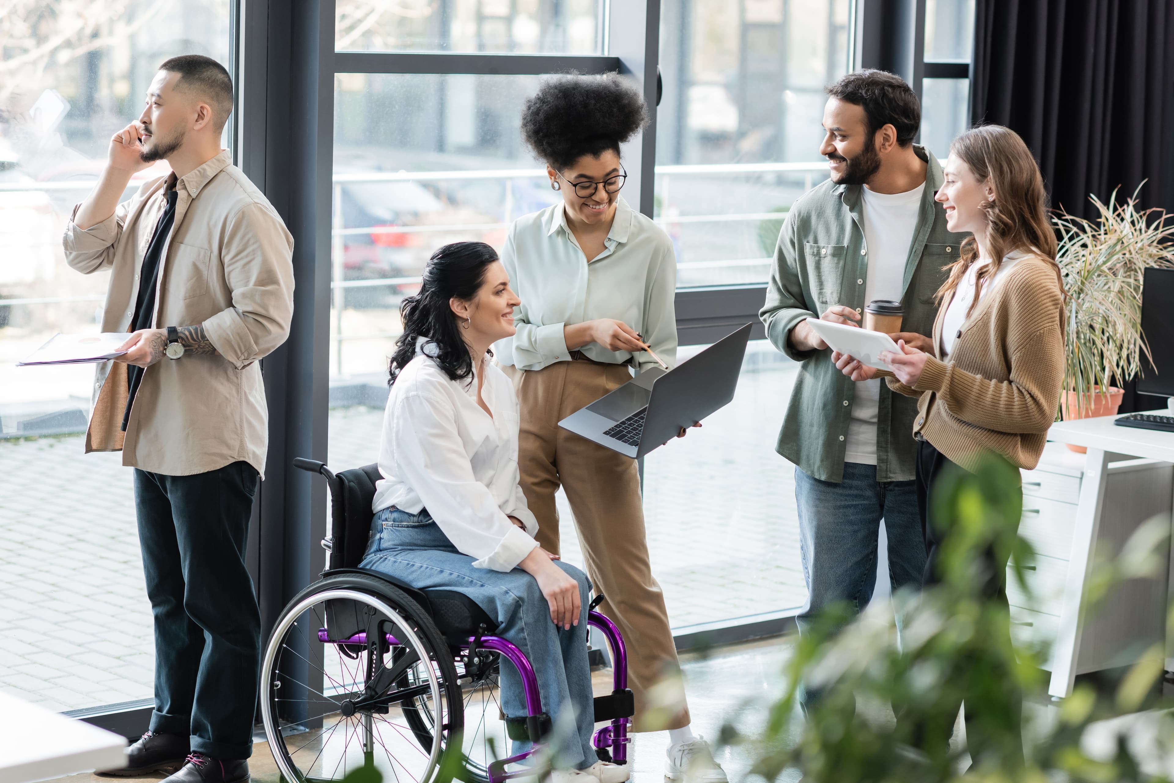 Cheerful interracial business people with disabled woman